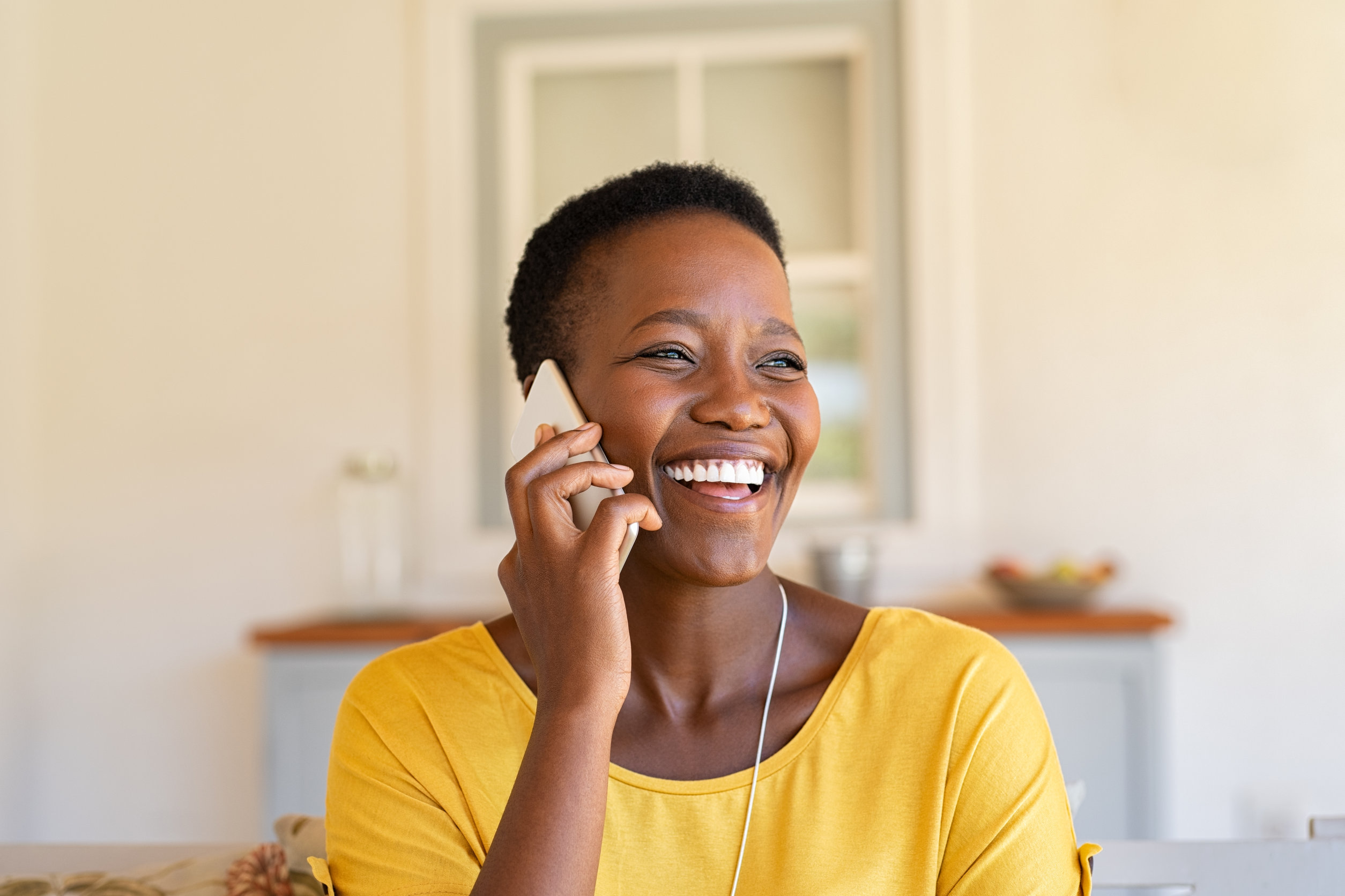 woman laughing while scheduling handyman services on phone
