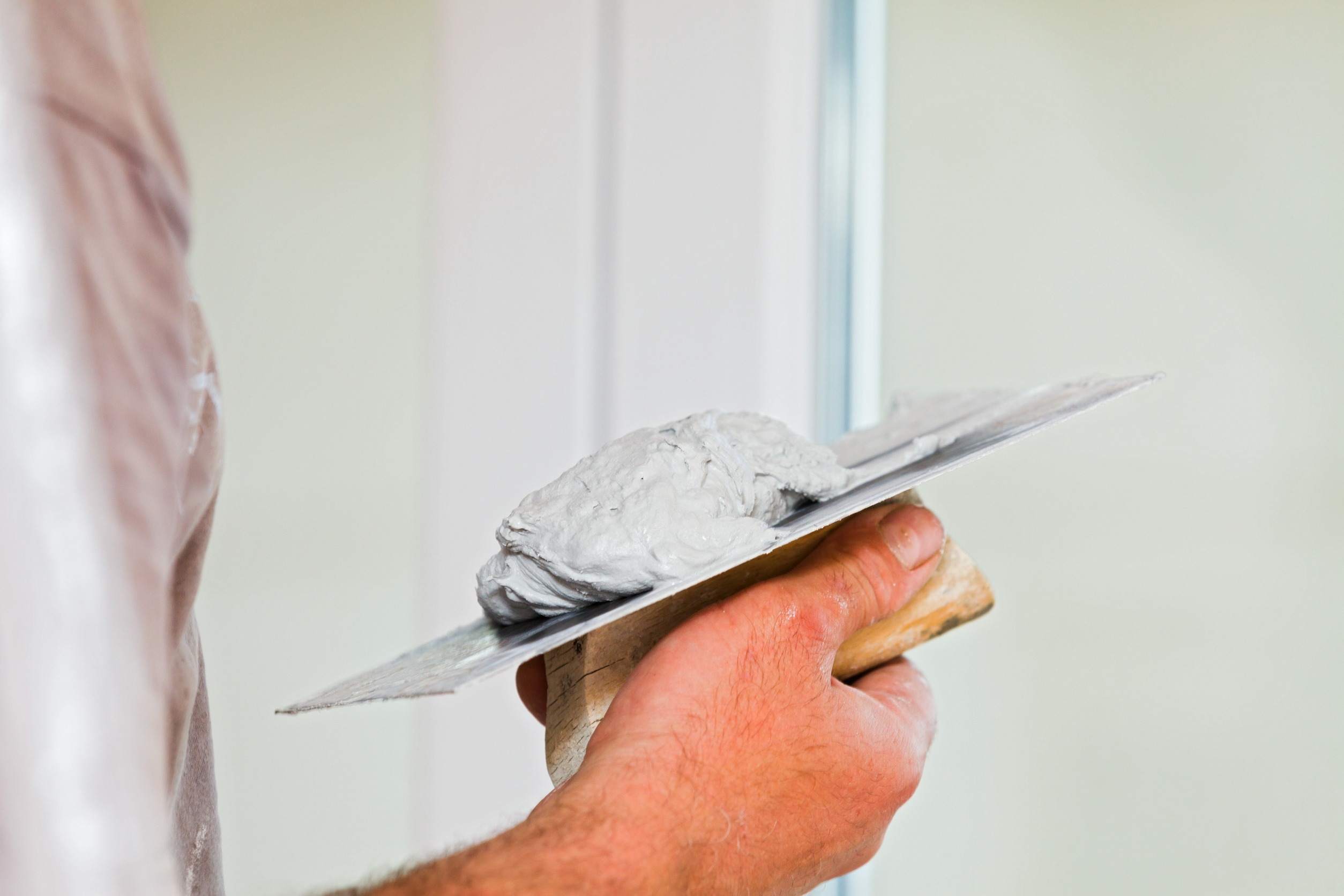 Handyman with drywall compound on a trowel